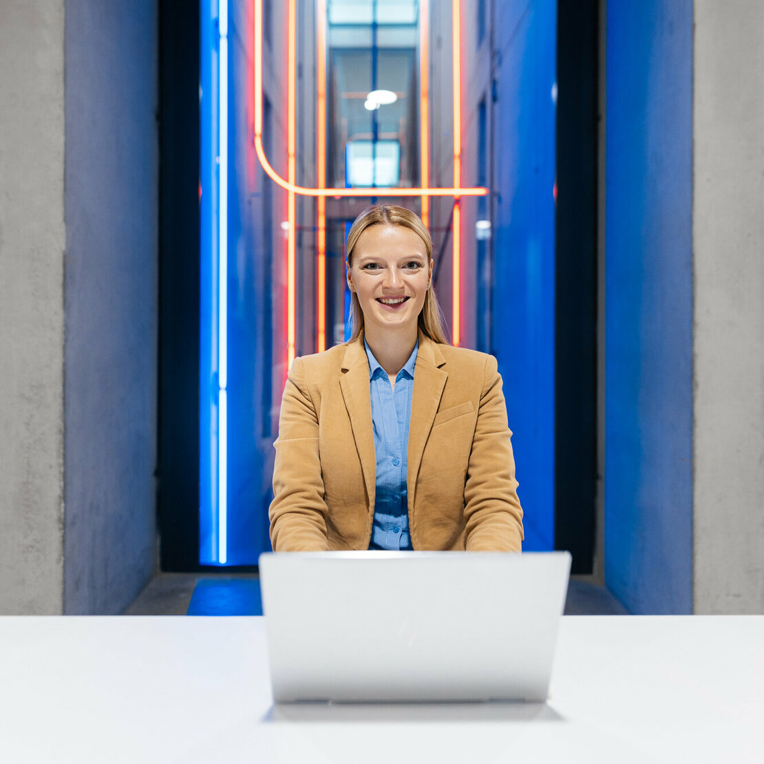 Frau vor Laptop mit futuristischem Hintergrund